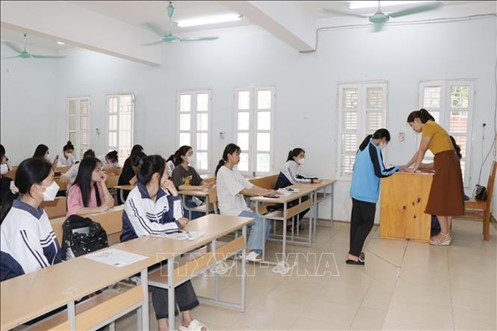 Giám thị kiểm tra, đối chiếu thông tin của thí sinh tại điểm thi Trường THPT Tô Hiệu, thành phố Sơn La, chiều 27/6. Ảnh: Hữu Quyết/TTXVN