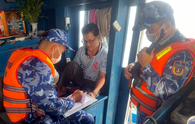 Cảnh sát biển lấy lời khai thuyền trưởng Huỳnh Tấn Kiệt. Ảnh: Hồng Vân