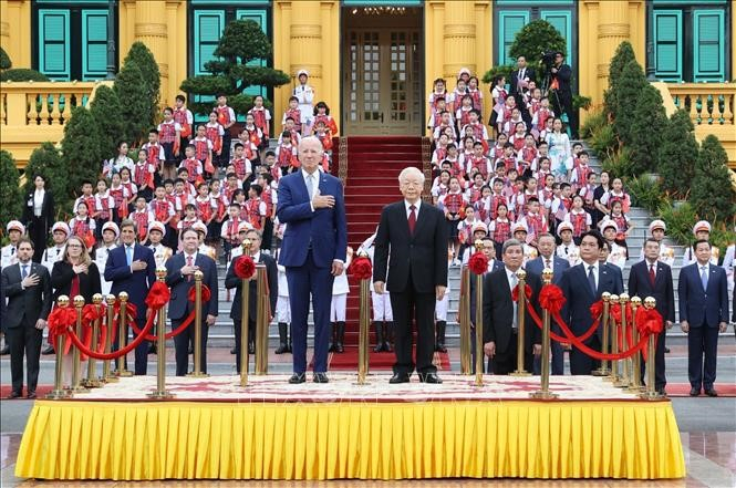 Tổng Bí thư Nguyễn Phú Trọng và Tổng thống Hoa Kỳ Joe Biden trên bục danh dự, thực hiện nghi thức chào cờ. Ảnh: Trí Dũng/TTXVN