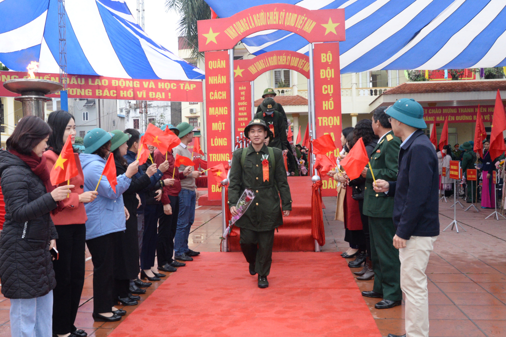 Các tân binh huyện Văn Giang bước qua cầu vinh quang trước khi lên xe về các đơn vị nhận quân