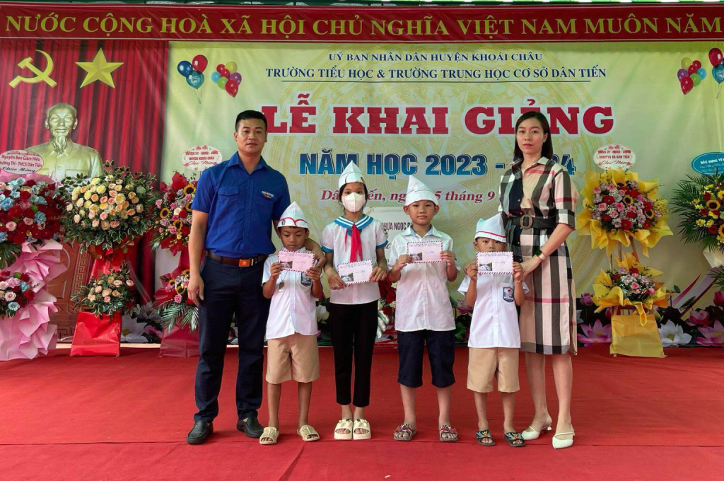 Gia đình anh Nam, chị Thương và Đoàn xã Dân Tiến trao học bổng tặng học sinh nghèo tại trường Tiểu học và Trung học cơ sở Dân Tiến