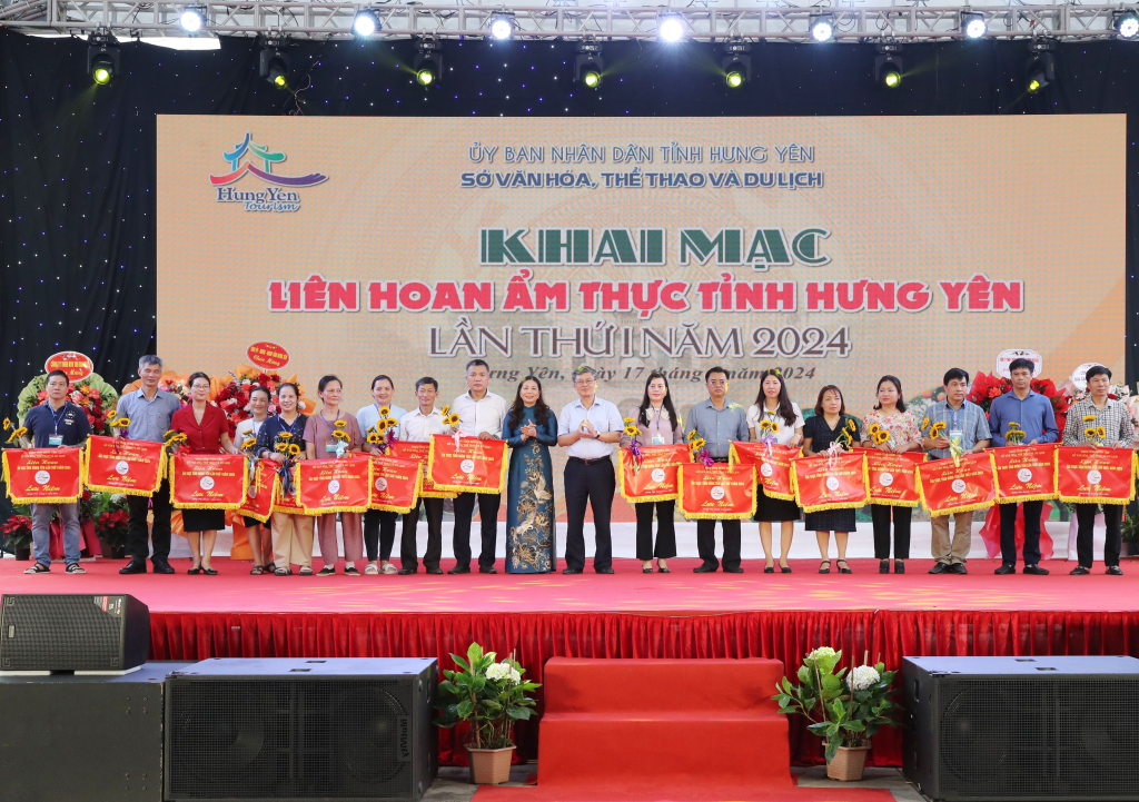 Phó Chủ tịch UBND tỉnh Nguyễn Duy Hưng và Phó Chủ tịch HĐND tỉnh Trần Thị Tuyết Hương trao cờ lưu niệm tặng các đơn vị tham gia liên hoan