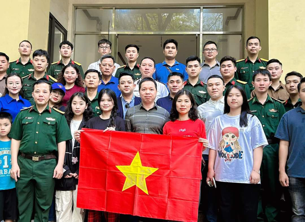 Cô giáo Lê Thị Hài (người cầm cờ bên phải ảnh) cùng nhóm tác giả và đoàn đại biểu tỉnh Hưng Yên đi Điện Biên nhận giải trong Lễ xuất quân tại số 2 Lý Nam Đế (Hà Nội) ngày 25/4