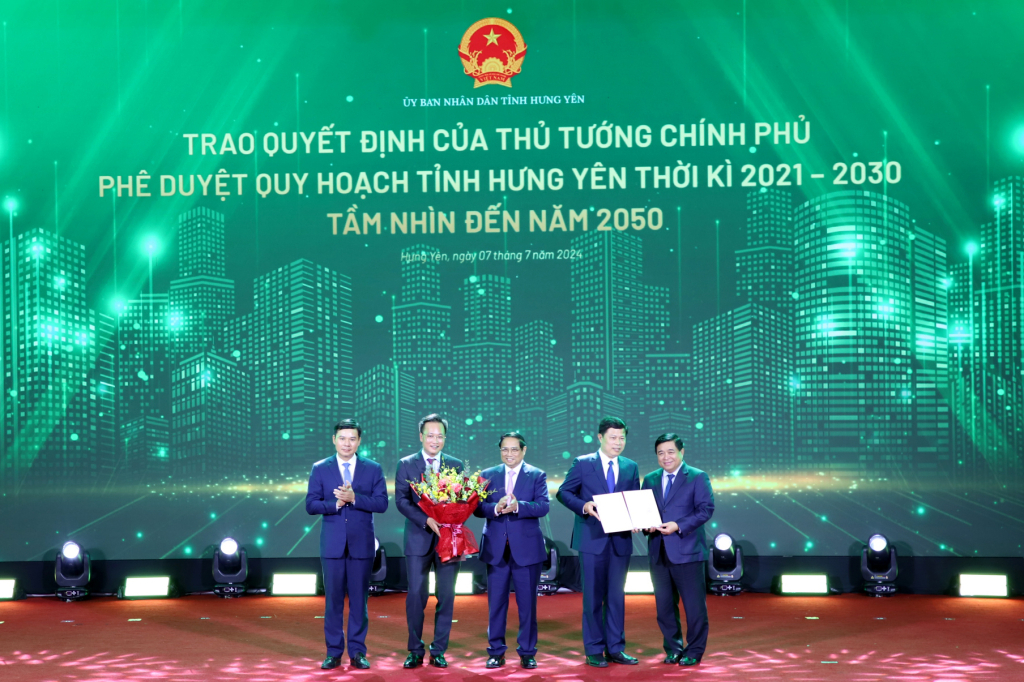 Prime Minister Pham Minh Chinh and Minister of Planning and Investment Nguyen Chi Dung presented the decision approving the Master plan of Hung Yen province for the period 2021 - 2030, with a vision to 2050, and offered flowers to congratulate the province.