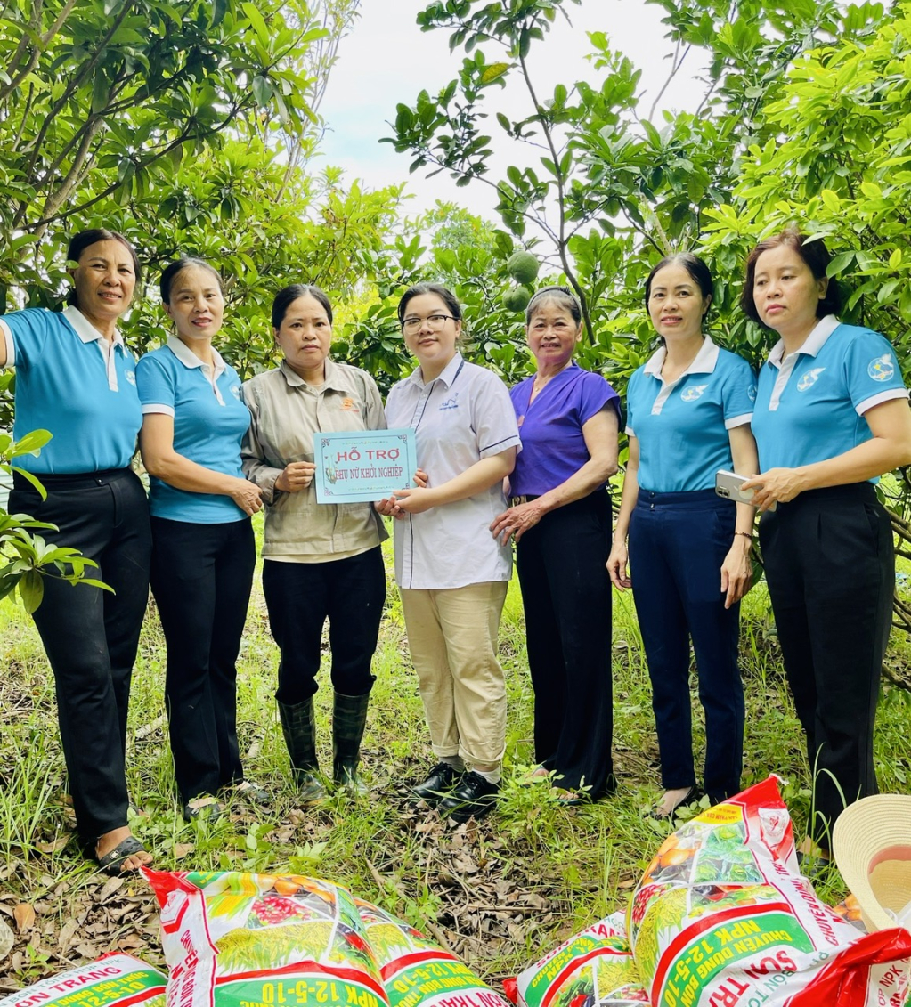 Nữ sinh Nguyễn Thị Kim Ngân (áo trắng đứng giữa) trao hỗ trợ sinh kế cho hội viên phụ nữ có hoàn cảnh khó khăn của xã Lạc Đạo