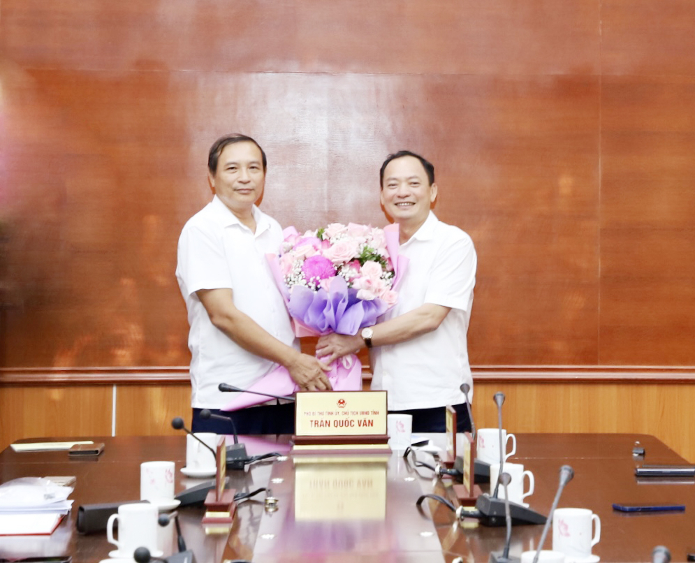 Chủ tịch UBND tỉnh Trần Quốc Văn tặng hoa chúc mừng đồng chí Nguyễn Văn Phê, nguyên Giám đốc Sở Giáo dục và Đào tạo