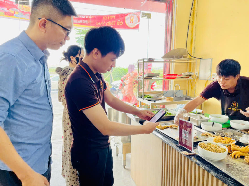 Nhân viên quán phở gà Tiến Vua hướng dẫn khách hàng quét mã QR chuyển tiền đến số tài khoản tiếp nhận ủng hộ đồng bào bị thiệt hại do bão số 3 của Ủy ban Trung ương MTTQ Việt Nam 