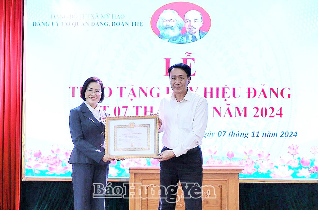 Đồng chí Trưởng ban Tổ chức Tỉnh ủy Phạm Văn Khuê trao Huy hiệu 30 năm tuổi Đảng tặng đảng viên Trần Thị Thanh Thủy