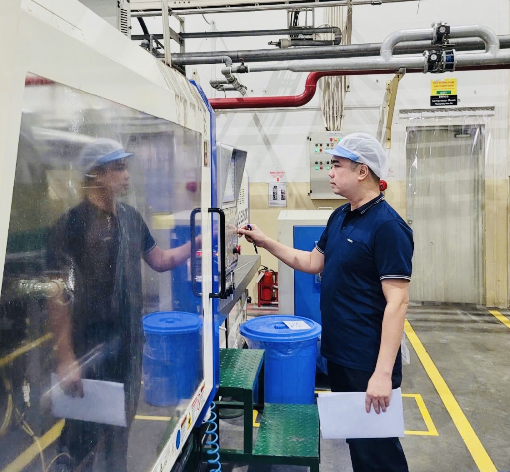 Anh Nguyễn Văn Luận kiểm tra hệ thống máy tự động tại khu vực sản xuất