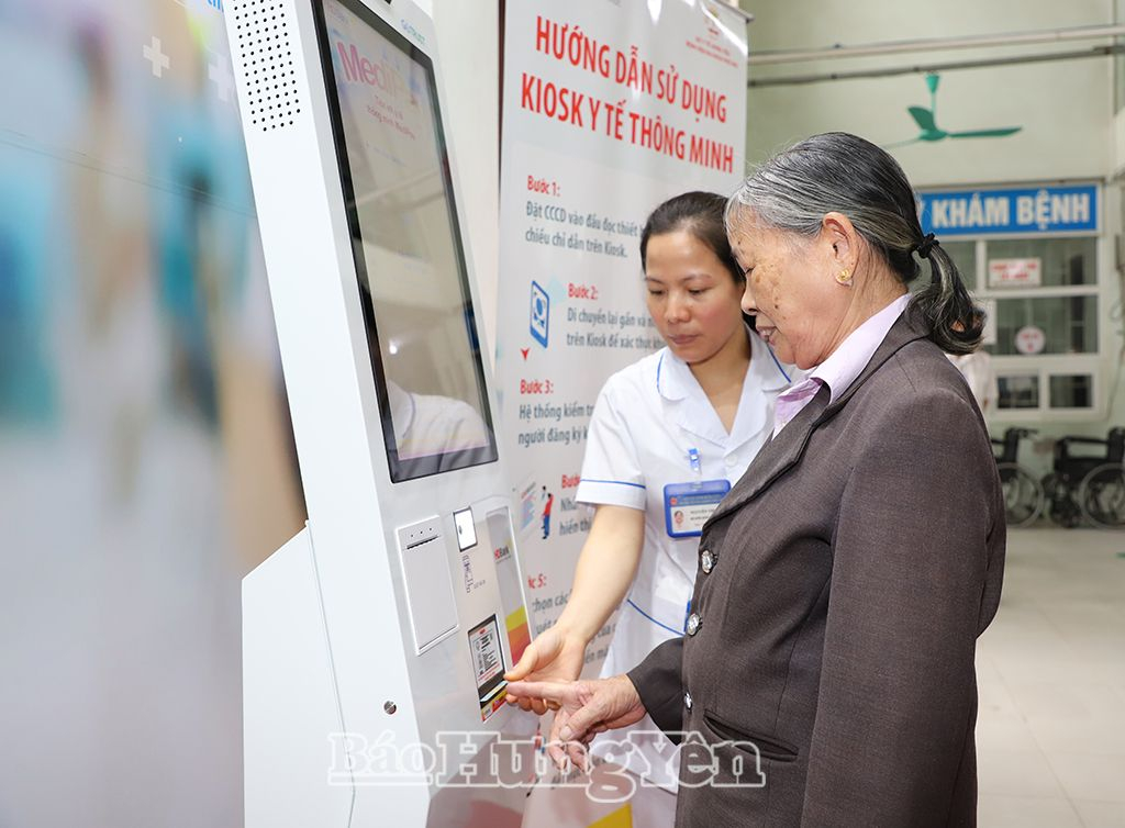 Nhân viên y tế Bệnh viện Đa khoa Phố Nối hướng dẫn người dân sử dụng kiosk y tế thông minh
