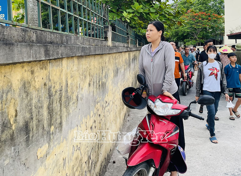 Một phụ huynh cố gắng tìm vị trí cao để nhìn vào phía trongkhu vực thi