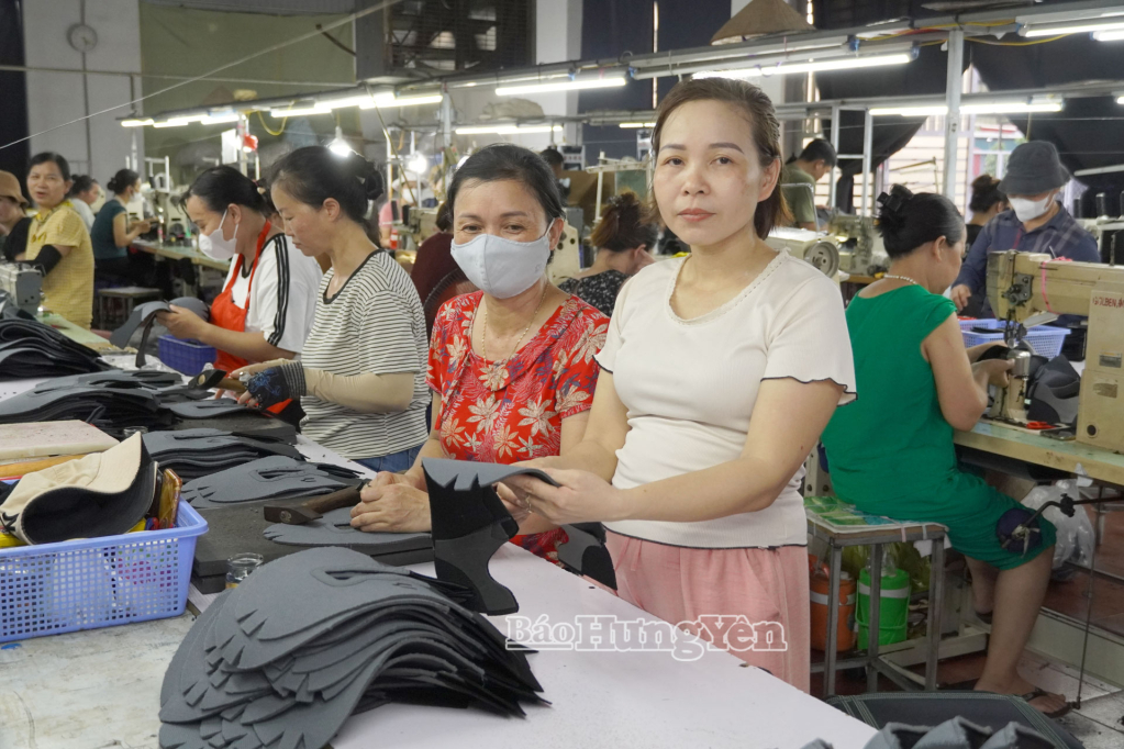 Chị Tô Thị Hạnh (bên phải), chủ xưởng may gia công mũi giày hướng dẫn công nhân kiểm tra sản phẩm.