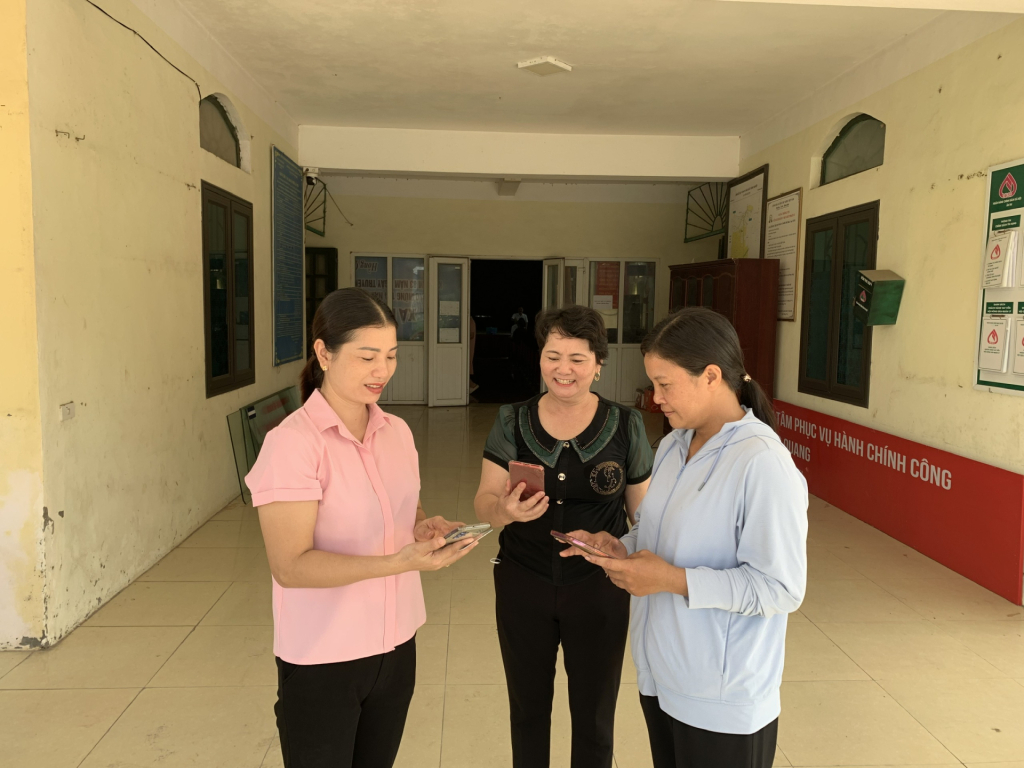 Người dân xã Hồng Quang hướng dẫn nhau cách xem thông tin trên fanpage của xã.