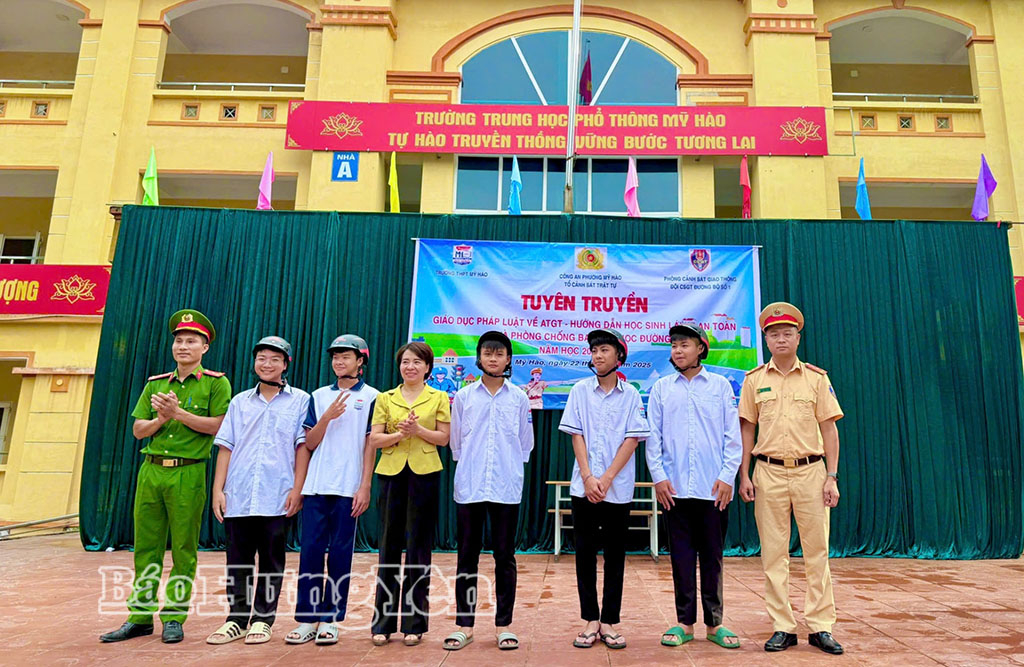 Công an phường Mỹ Hào phối hợp trao tặng mũ bảo hiểm cho học sinh Trường THPT Mỹ Hào. Ảnh: Thu Trang 