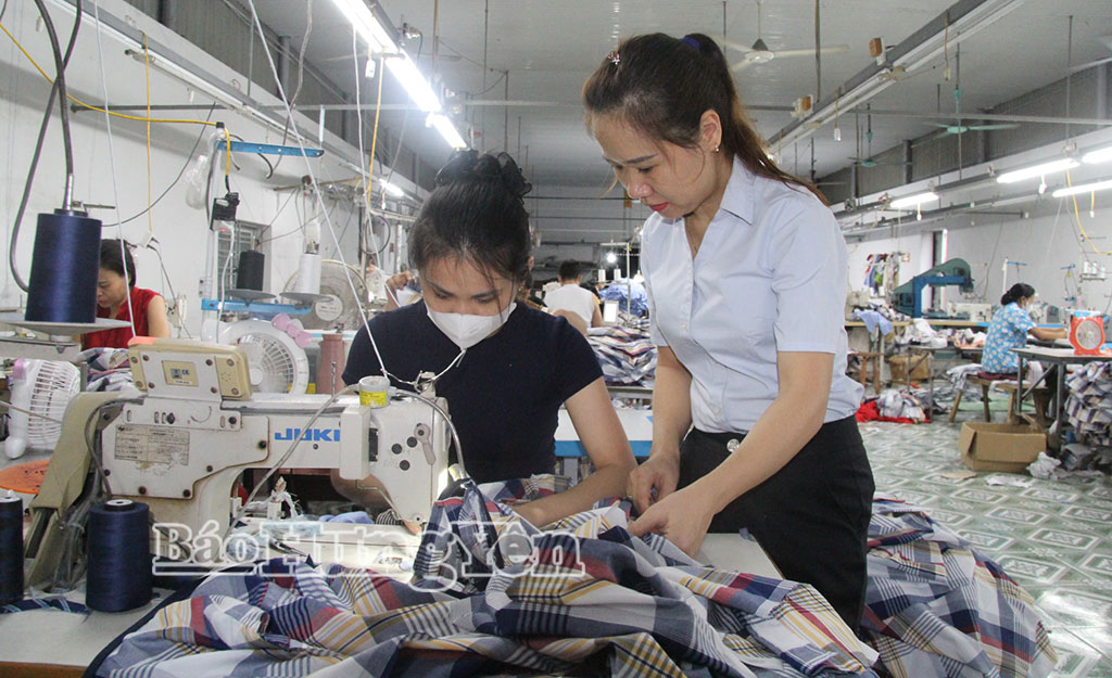 Chị Lê Thị Thu Thủy, thôn Thống Nhất, xã Thần Khê (bên phải)hướng dẫn kỹ thuật cho công nhân.