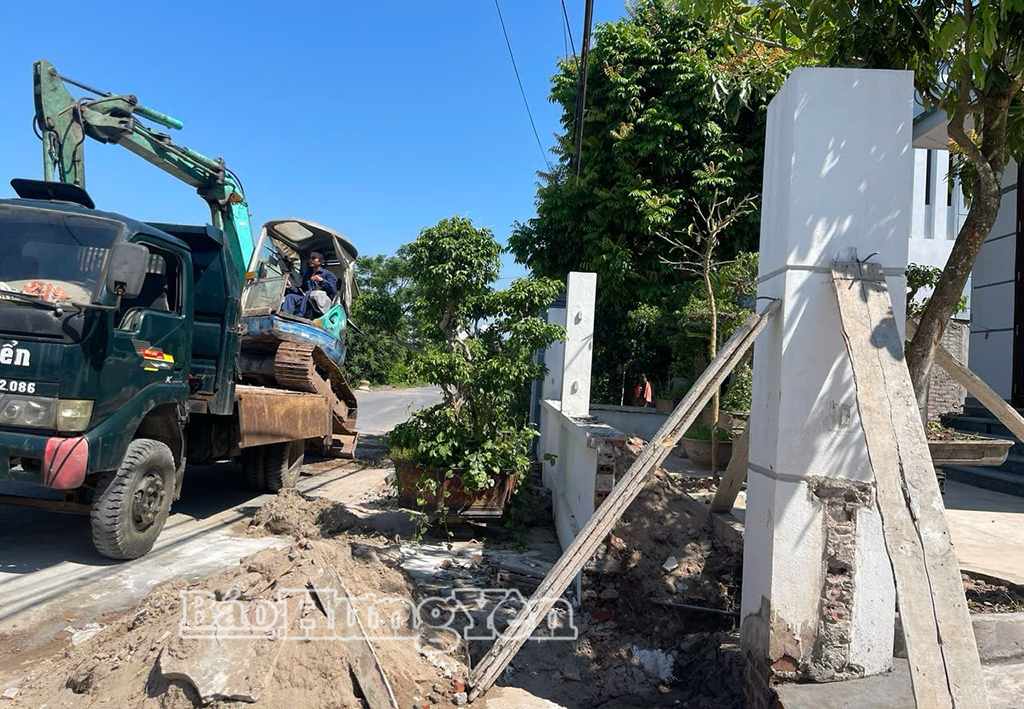 Người dân thôn Đồng Châu Nội huy động máy móc để tháo dỡ công trình tường bao mở rộng tuyến đường ĐT.464.