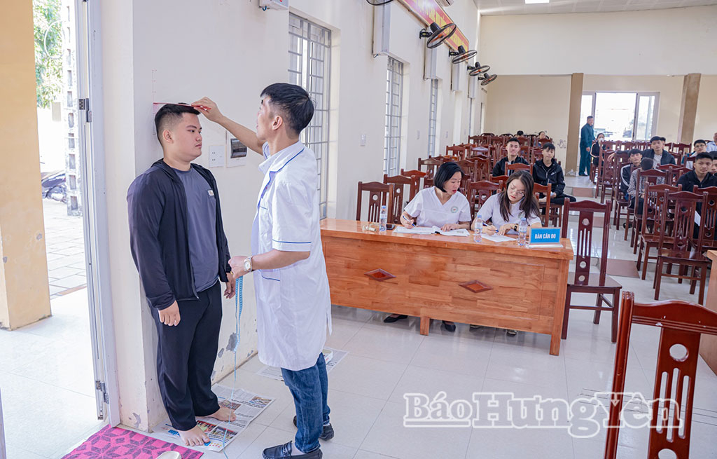Cán bộ y tế đo chiều cao cho thanh niên tham gia sơ tuyển tại xã Châu Ninh. Ảnh: Hương Giang