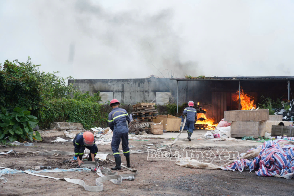 Cảnh sát phòng cháy, chữa cháy triển khai vòi nước tiếp cận đám cháy trong kho.