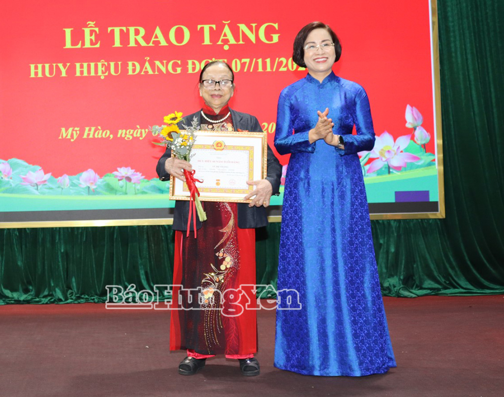 Đồng chí Bí thư Đảng ủy phường Mỹ Hào Trần Thị Thanh Thủy trao tặng Huy hiệu 60 năm tuổi Đảng cho đảng viên Lê Thị Thường.