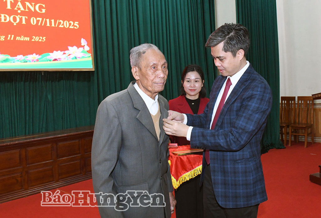Đồng chí Trưởng ban Tuyên giáo và Dân vận Tỉnh ủy Nguyễn Văn Chiến trao Huy hiệu 70 năm tuổi Đảng tặng đảng viên Trần Bá Tuất.