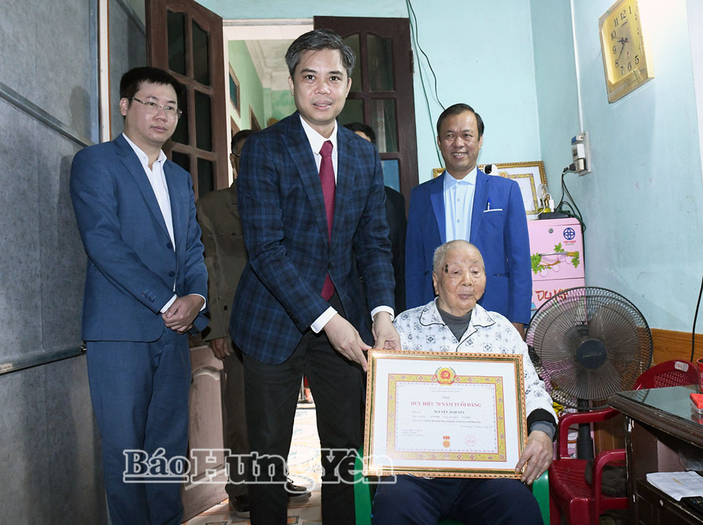Đồng chí Trưởng ban Tuyên giáo và Dân vận Tỉnh ủy Nguyễn Văn Chiến trao Huy hiệu 70 năm tuổi Đảng tặng đảng viên Nguyễn Ái Quyết.