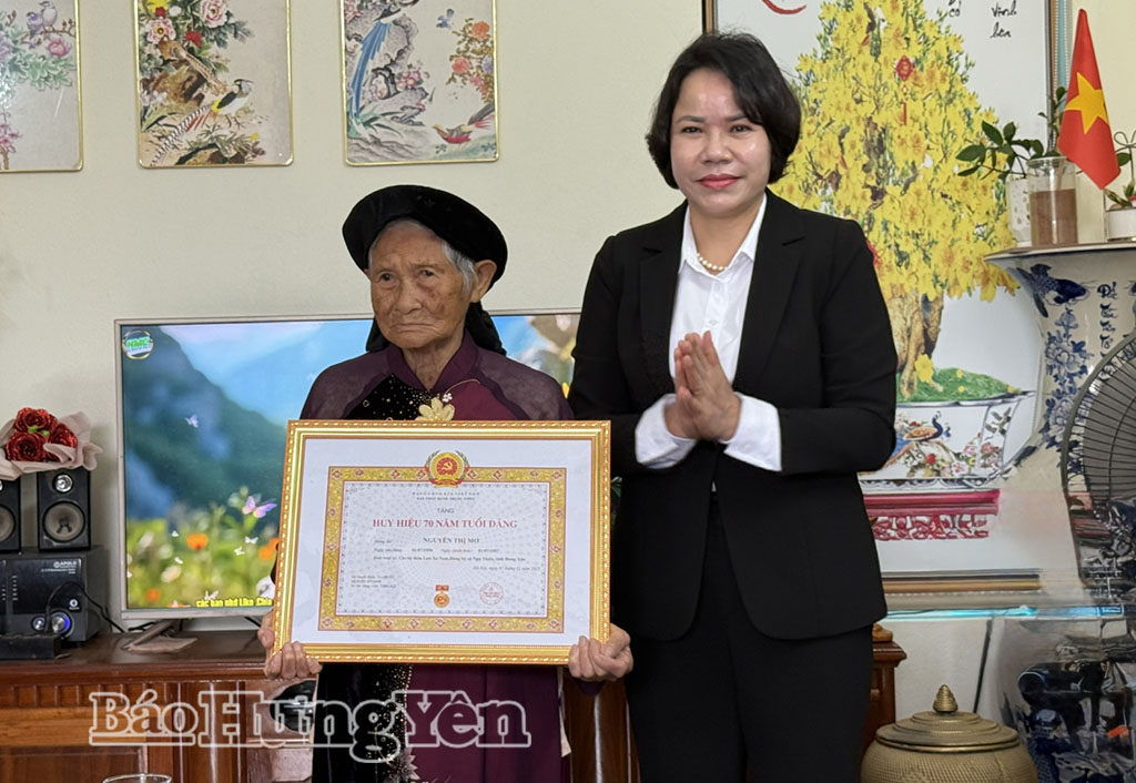 Đồng chí Quách Thị Hương, Ủy viên Ban Thường vụ Tỉnh ủy, Hiệu trưởng Trường Chính trị Nguyễn Văn Linh trao Huy hiệu 70 năm tuổi Đảng tặng đảng viên Nguyễn Thị Mơ.  Ảnh: Hồng Hạnh