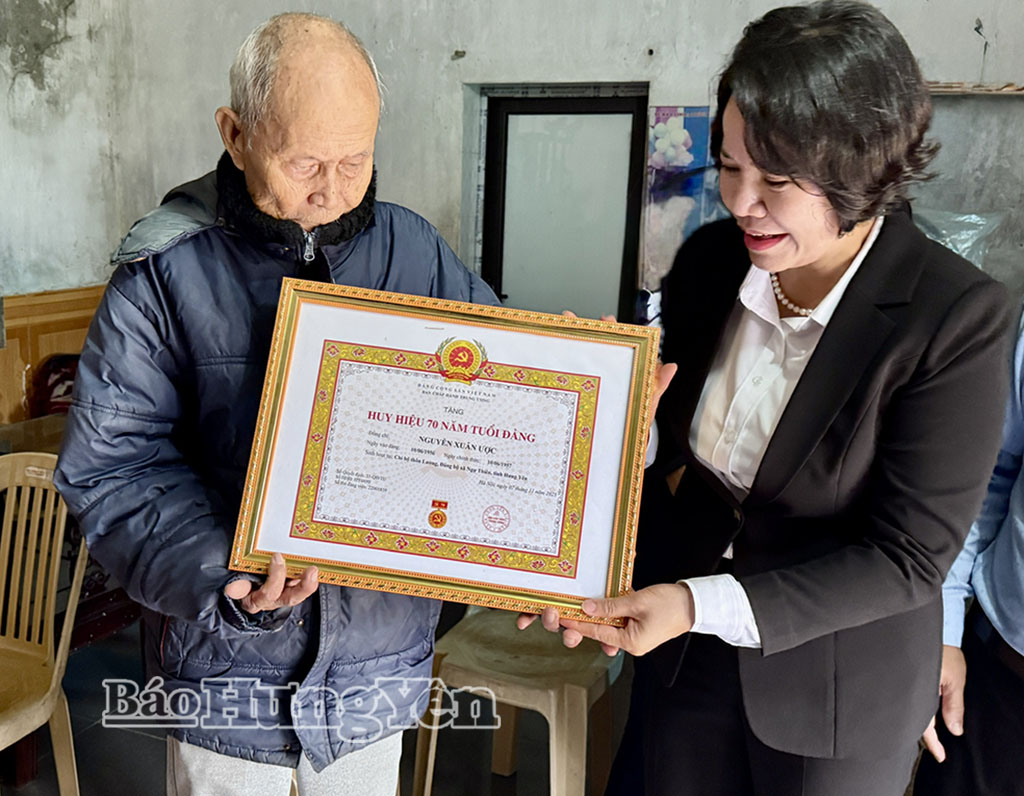 Đồng chí Quách Thị Hương, Ủy viên Ban Thường vụ Tỉnh ủy, Hiệu trưởng Trường Chính trị Nguyễn Văn Linh trao Huy hiệu 70 năm tuổi Đảng tặng đảng viên Nguyễn Xuân Ược. Ảnh: Hồng Hạnh