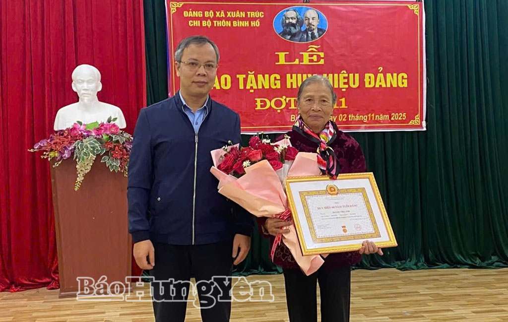 Lãnh đạo xã Xuân Trúc trao Huy hiệu 60 năm tuổi đảng tặng đảng viên Hoàng Thị Cảnh, sinh hoạt tại Chi bộ thôn Bình Hồ. Ảnh: Đào Doan