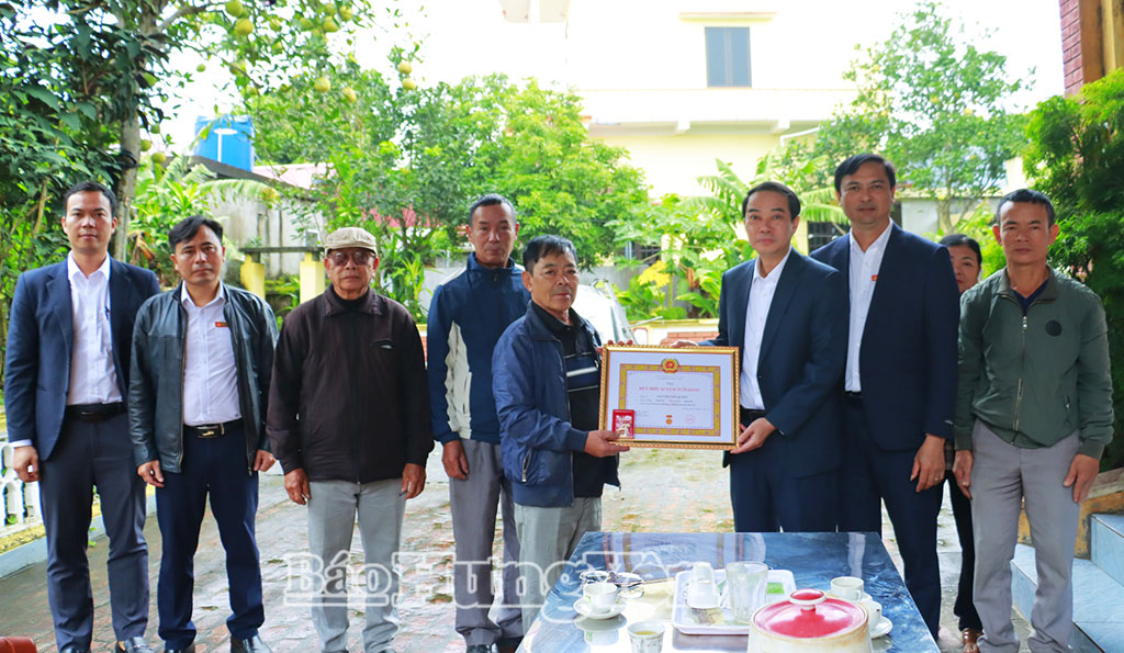 Lãnh đạo Đảng ủy xã Đông Hưng trao Huy hiệu 65 năm tuổi đảng cho thân nhân đảng viên Nguyễn Như Quyền. Ảnh: Thu Hiền