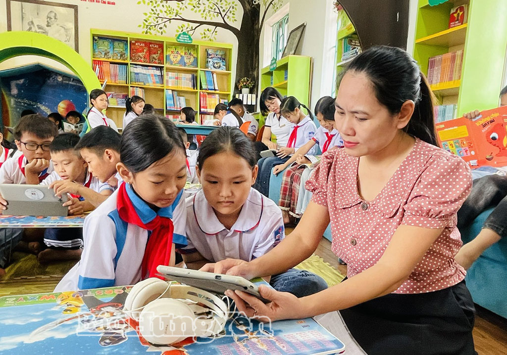 Giáo viên Trường Tiểu học Duyên Hải, xã Diên Hà hướng dẫn học sinh truy cập phần mềm đọc sách.