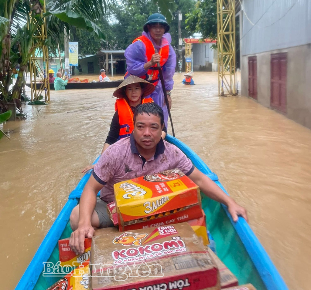 Tình nguyện viên CLB hũ gạo tình thương xã Lạc Đạo vận chuyển nhu yếu phẩm vào tận nhà người dân bị ngập để trao tặng.