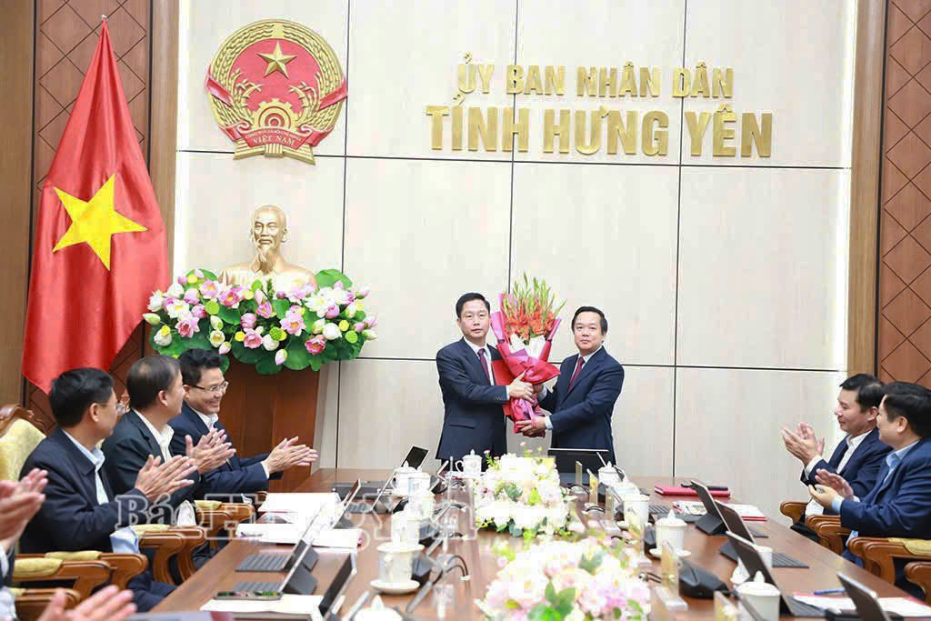 Đồng chí Phạm Quang Ngọc, Phó Bí thư Tỉnh ủy, Chủ tịch UBND tỉnh trao quyết định và tặng hoa chúc mừng đồng chí Vũ Thanh Vân, Giám đốc Sở Công Thương.