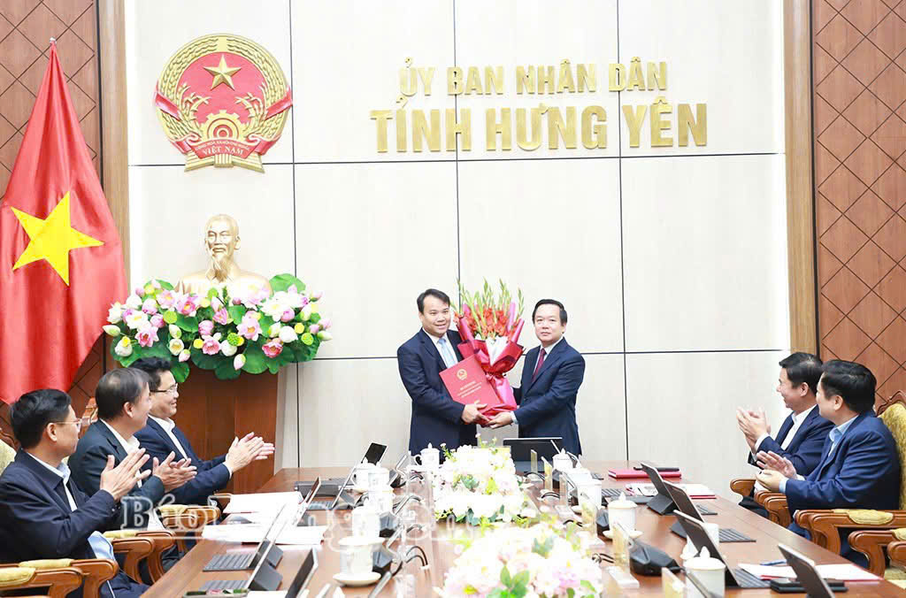 Đồng chí Phạm Quang Ngọc, Phó Bí thư Tỉnh ủy, Chủ tịch UBND tỉnh trao quyết định và tặng hoa chúc mừng đồng chí Cao Quang Hưng, Trưởng Ban quản lý các khu công nghiệp tỉnh.