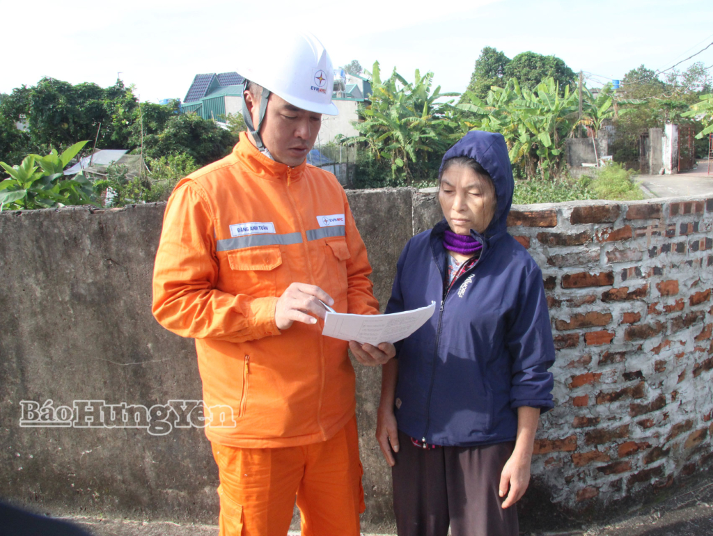 Bà Lê Thị Hằng, ở xã Quang Lịch, được công nhân Đội quản lý điện khu vực Kiến Xương hướng dẫn các tiện ích dịch vụ điện.