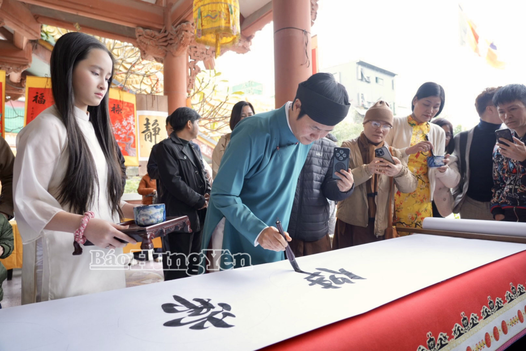 Thư pháp gia thực hiện nghi thức viết trường quyển trong chương trình khai bút đầu xuân.